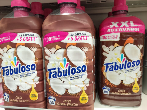 Rome, Italy - July 23, 2025: Fabuloso coconut and white flowers scented fabric softener bottles displayed on supermarket shelf, showcasing vibrant packaging and enticing fragrance options