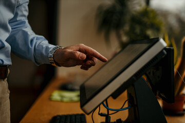 Businessman pointing at touchscreen computer in office setting