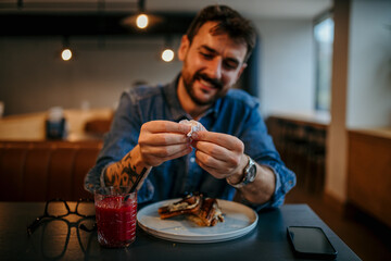 Customer opening sugar packet at restaurant table with food and drink