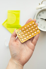 Close-up of birth control pill pack in female hand, hormonal contraception.