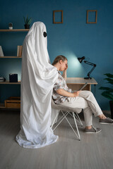 Concept of afterlife and memory for lost love. Sad woman sitting on chair while male ghost standing...