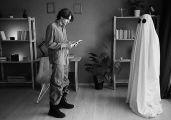 Lonely widower stares at picture of lost wife while ghost of woman watches him from nearby....