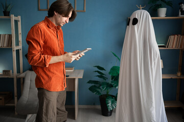 Widower alone with picture of his lost love. Wife ghost stands close, unseen. Concept of afterlife,...