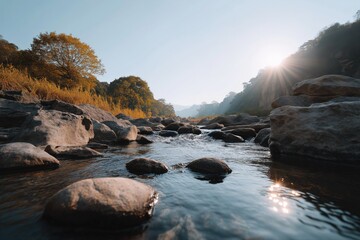 Fototapeta premium Serene river stream with rocky banks at sunrise in tranquil autumn landscape