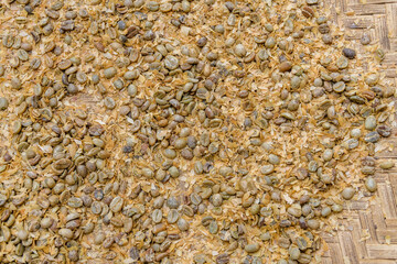 Heap of the peeled raw coffee beans on plate