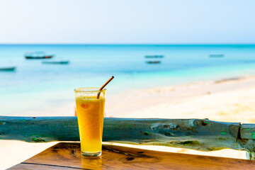 Juice of pineapple and orange. Ocean at the background