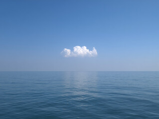 Serene ocean horizon with a single fluffy cloud under a clear blue sky
