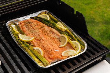Grilled salmon fillets and asparagus sizzling on a barbecue grill