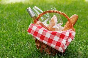 Picnic basket with wine, grapes, and baguette