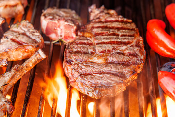 Juicy steaks and bell peppers sizzling on a grill