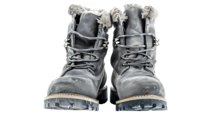 A pair of worn gray work boots with laces and fur lining isolated on a solid color surface