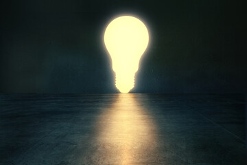 Glowing light bulb in dark empty room.