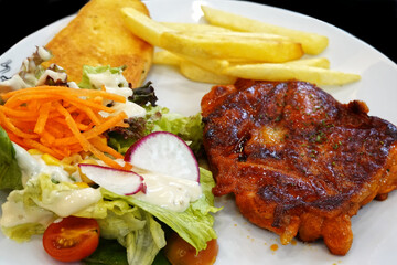 Chicken steak with mixed salad, garlic bread and French fries serving set menu.