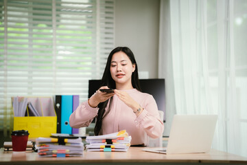 A cheerful businesswoman organizes stacks of documents at her desk, surrounded by charts, folders,...