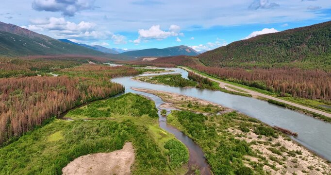 Moving fast over the delta of the branching river. Beautiful mountains surround the area. Alaska landscapes.