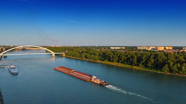 Water vehicles move by the Danube on sunny day. View on the Appolo bridge in Bratislava, Slovakia.
