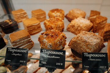 Lots of tasty sweet cakes with honey on a stand with price, delicious festive dessert