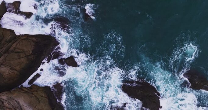 Aerial view seashore cliffs wave crashing on rocks, Beautiful dark sea surface in sunny day at the phuket island, Phuket Thailand