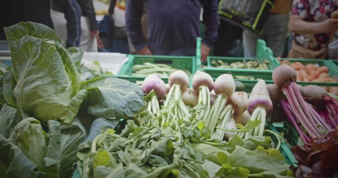 People buying organic vegetables at Lavradores Market in Madeira, surrounded by fresh local produce