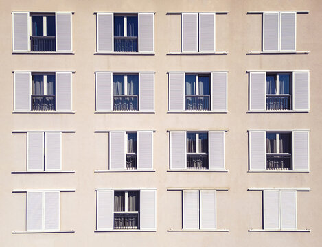 Fototapeta Aerial view of a symmetrical facade with white framed windows and partially closed shutters creating a rhythmic pattern of light and shadow, Split, Split-Dalmatia County, Croatia.