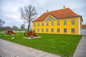 The vibrant yellow Commander's House stands proudly in Kastellet, Copenhagen, surrounded by...
