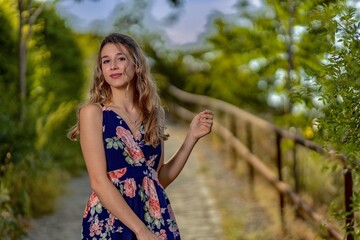 Serene Portrait of a Young Woman in a Floral Dress on a Nature Path