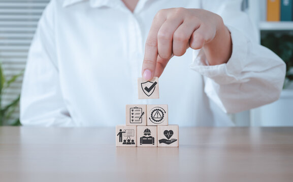 Work safety and compliance concept. Stacking wooden blocks with shield icon, including compliance, health, inspection, training, protection, regulatory, workplace safety, risk management, Safety First