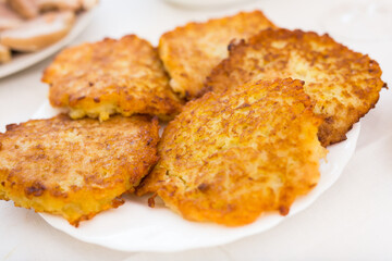 Potato pancakes with sour cream on white plate