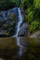 Waterfall in deep tropical rainforest with green rainy tree nature landscape