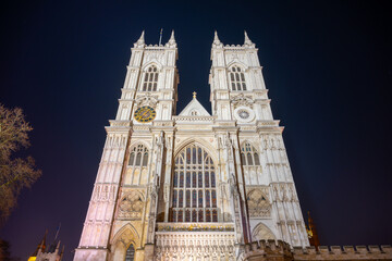 Westminster Abbey stands majestically illuminated against the night sky, showcasing its intricate...