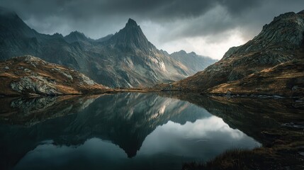 Mountain landscape with cloudy skies reflecting on tranquil lake in the early morning