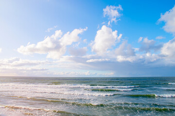 Blue sky with clouds over the sea. Calm landscape on the theme of travel and seaside recreation.