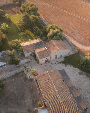 Aerial view of the rustic buildings of Rifugio Lanzagallo bask in the warm Sicilian sun, creating a tableau of earthy tones and textures, Rifugio Lanzagallo, Sicilia, Italy.