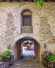 Naklejka premium Stone archway of a historic caravanserai in Sheki, Azerbaijan, with plants