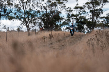 working in agriculture. girl riding a motorbike on a farm in outback Australia. Ranch worker...