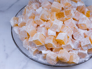 Delicious turkish delight cubes coated in powdered sugar on plate