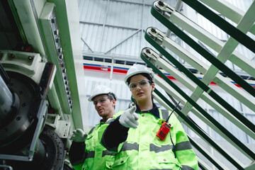 Engineering team communicates during inspection process of mechanical equipment in modern...