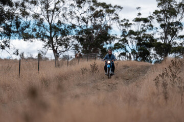 working in agriculture. girl riding a motorbike on a farm in outback Australia. Ranch worker...