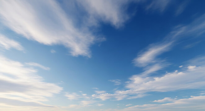 A serene view looking up at a vast blue sky with scattered, wispy white clouds.