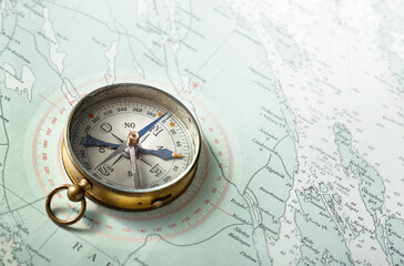 Compass on old map. Travel, geography, history, navigation, tourism and exploration concept background.  Retro compass on geography map.