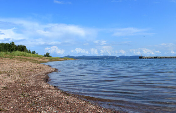 A beautiful summer morning on the shore of the Bratsk reservoir with clear water and a clear sky