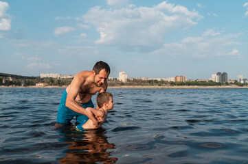 Dad Teaches Son to Swim in the River in Summer. Water Safety. Summer Childcare
