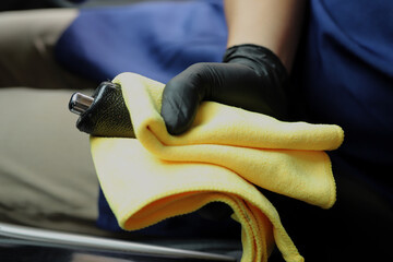 Staff use microfiber cloth to clean cars at car care shop.