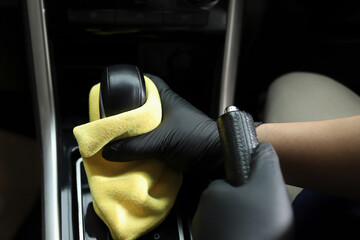 Staff use microfiber cloth to clean cars at car care shop.