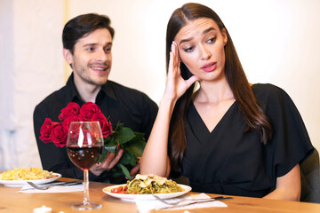 Dissatisfied frustrated beautiful lady ignoring rejecting excited emotional obsessed guy who...