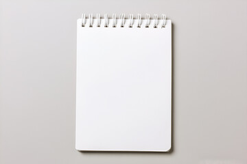 A blank white spiral-bound notepad is centered on a plain light gray background.