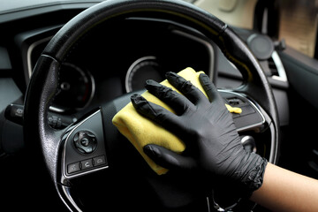 Staff use microfiber cloth to clean cars at car care shop.