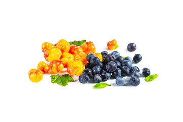 Ripe fresh blueberries and cloudberries with leaves isolated on white.