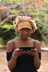 Smiling young black woman using her smart phone