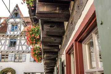 Detailaufnahme Untersicht mit Eichenbalken Auskragung und blühenden Balkonblumen schiefes Haus im...